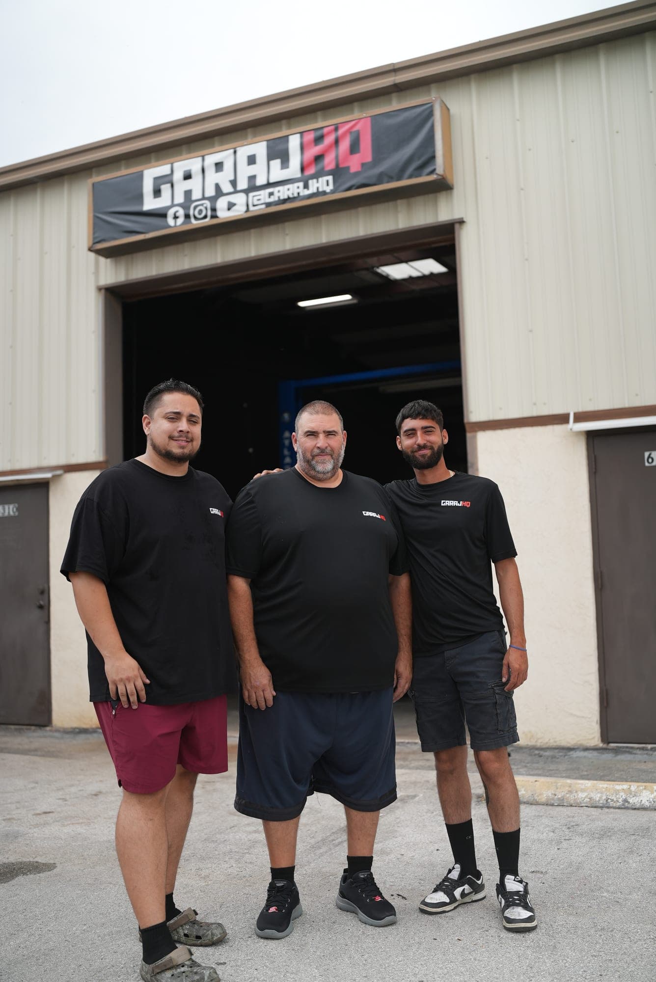 El equipo de GarajHQ frente al portón abierto del taller, bajo el letrero de GarajHQ en Homosassa, FL