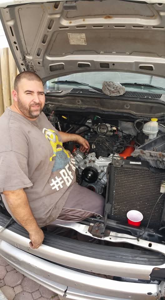 Trabajando en el motor de una camioneta en la entrada de la casa